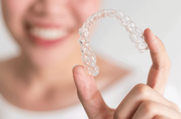 Women smiling holding Invisalign