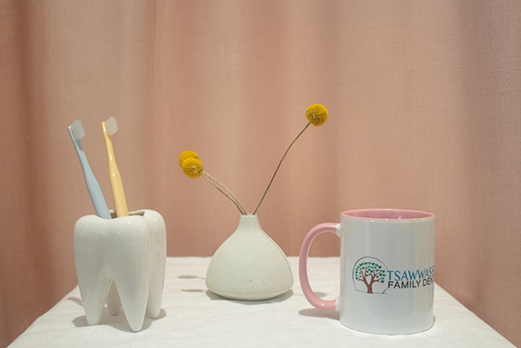 tooth sculpture with two toothbrushes, flower behind and Tsawwassen mug to the right