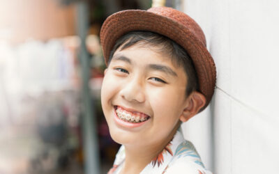 Smiling teenager with braces wearing a hat.