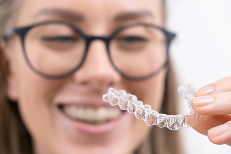 An image of a woman inspecting her invisalign